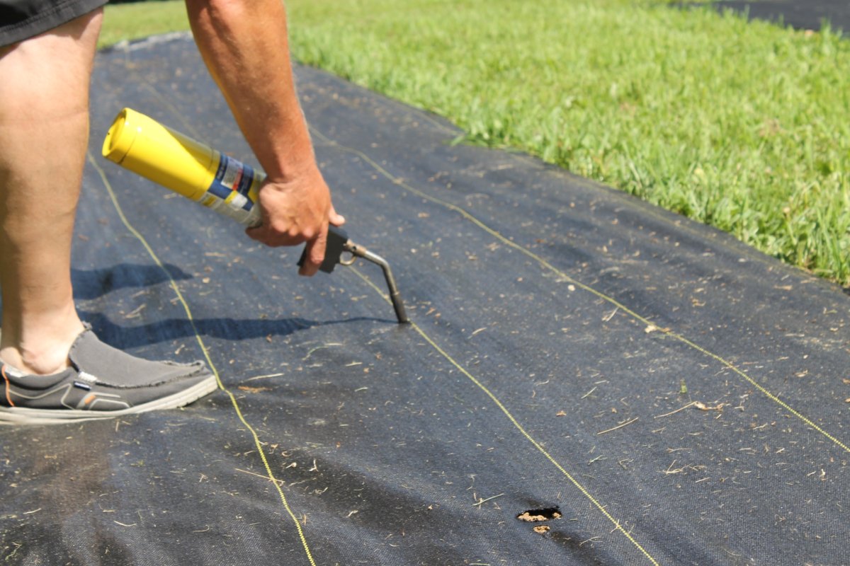 a man using Dewitt Landscape Fabric