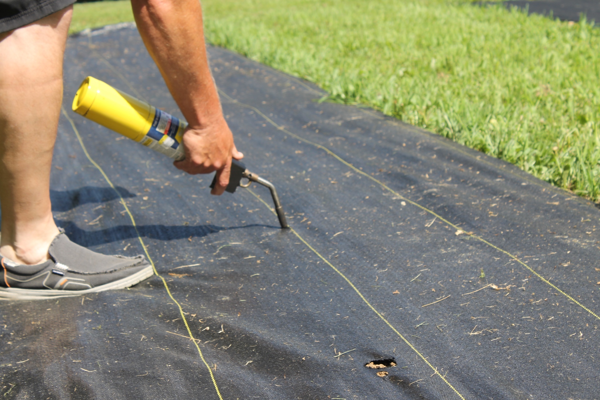 a man using Dewitt Landscape Fabric