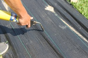 a man using Dewitt Landscape Fabric