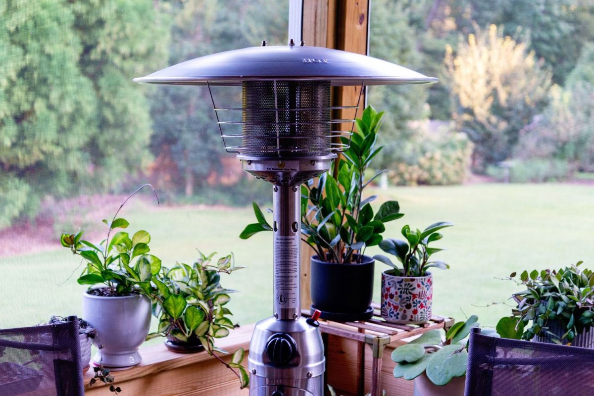 The best patio heater option set up on a table in a sunroom or porch with lots of cute houseplants in the background.