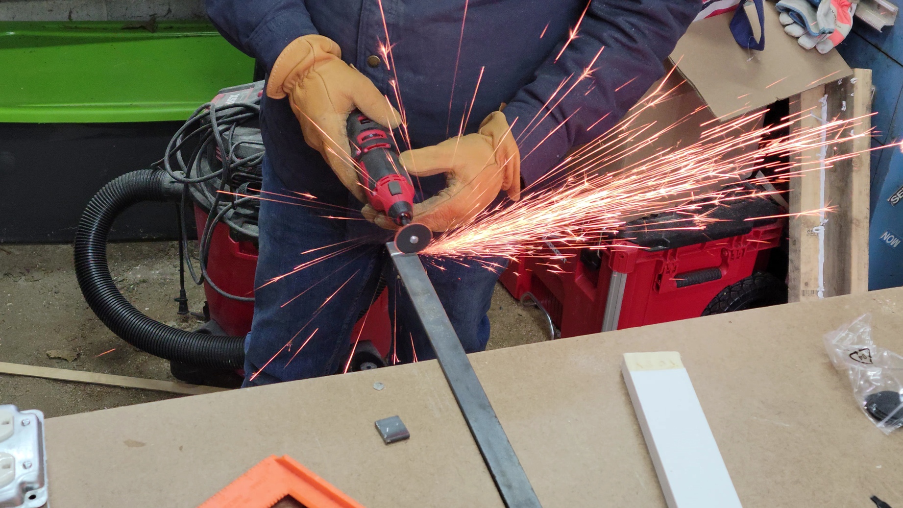 A person using the best rotary tool option to cut a strip of metal.