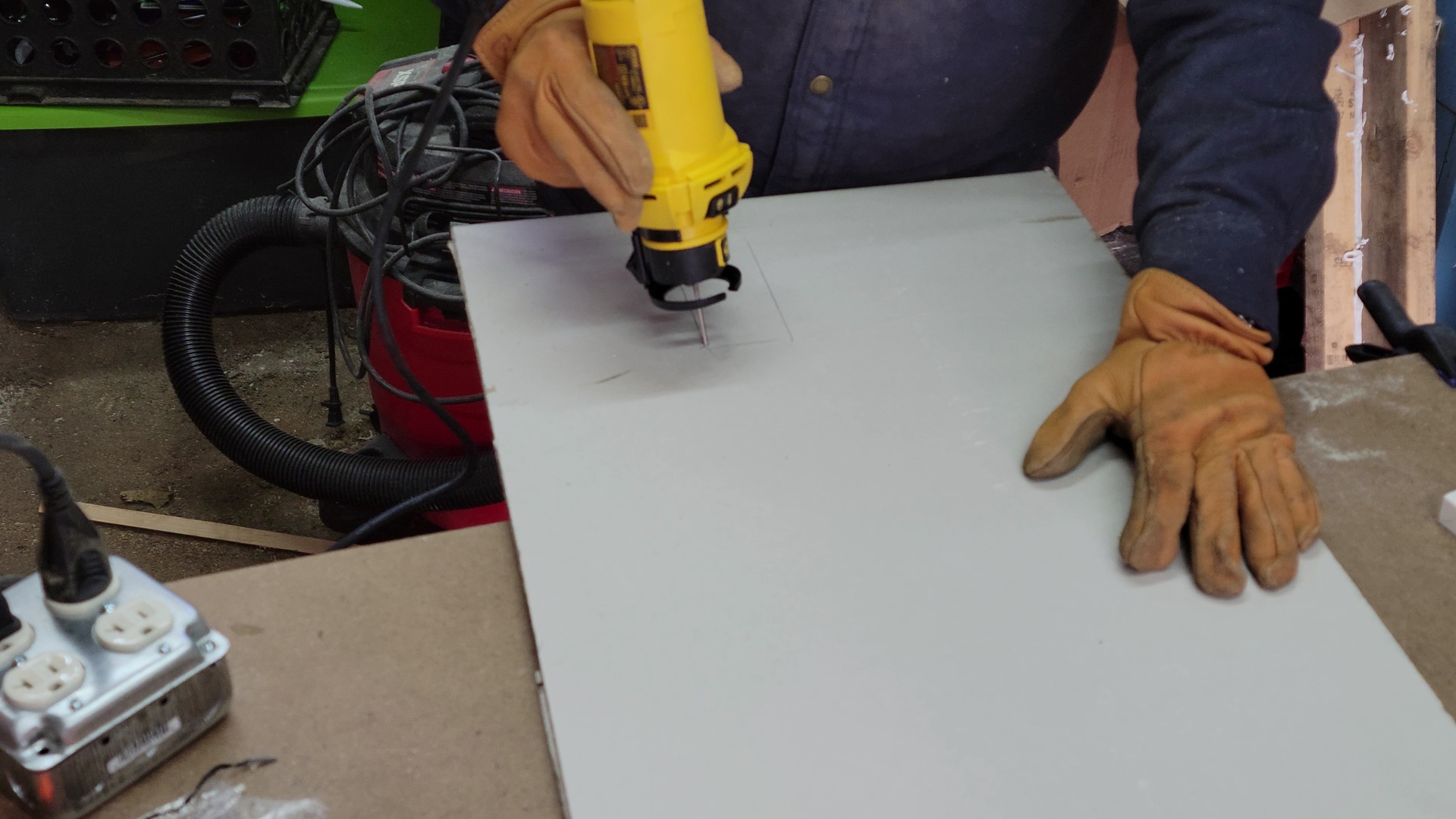 A person using the best rotary tool option to cut drywall.