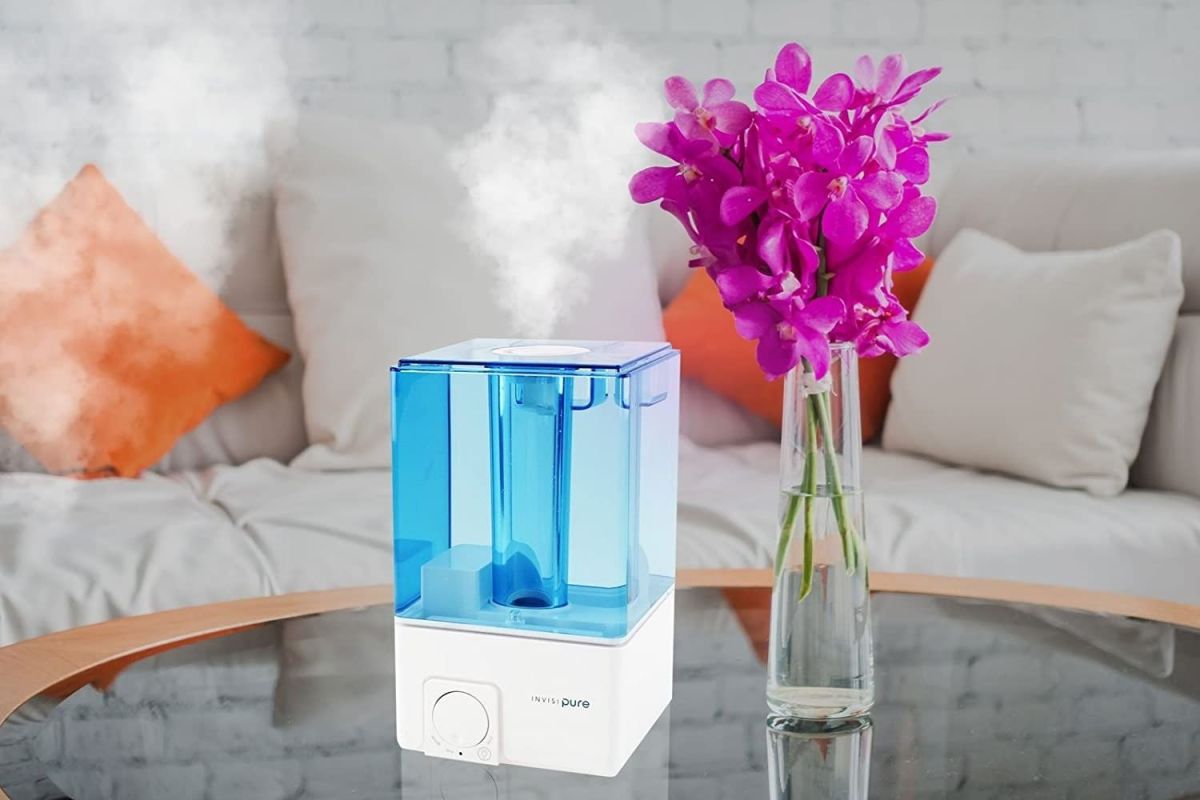 One of the best room humidifiers on a glass coffee table in a living room.