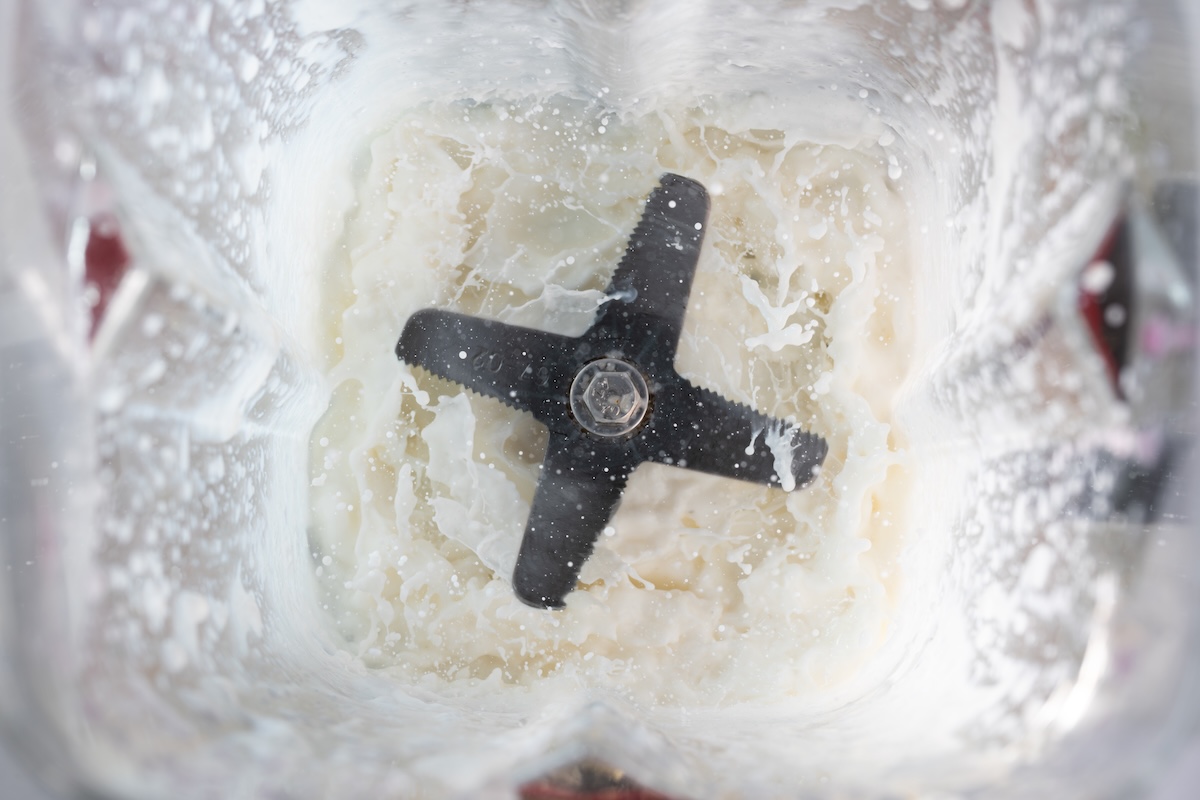 Birds' eye view of a white mixture in a blender.