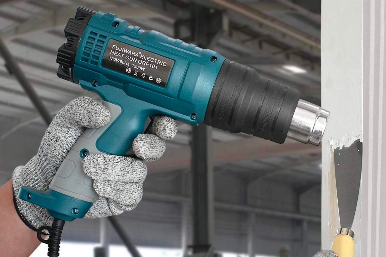 A person using the best heat gun option to remove paint