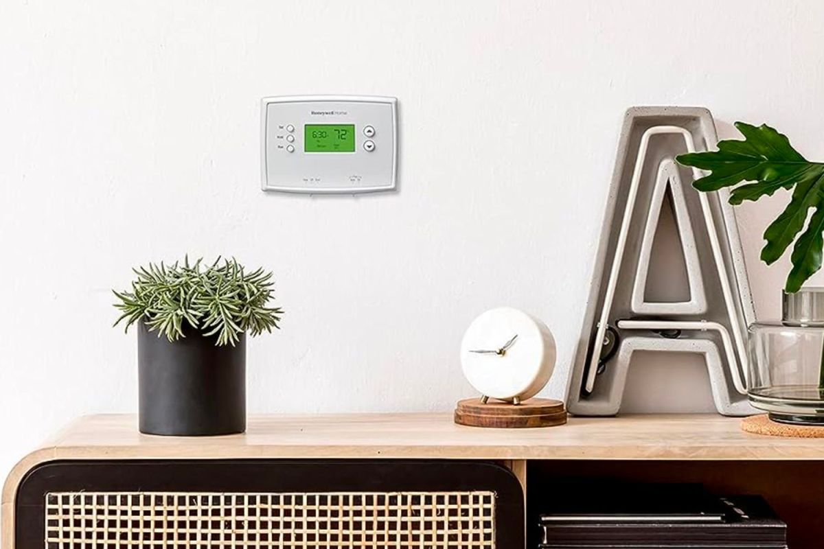 The best programmable thermostat mounted to the wall behind a desk