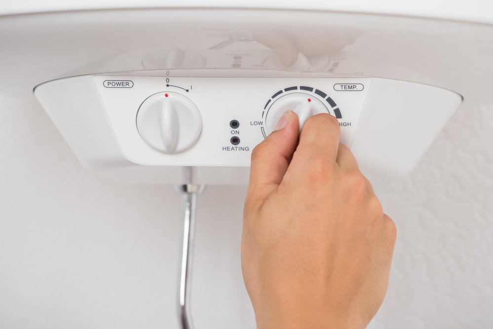 A person using a dial to adjust the setting on the best tankless water heater option