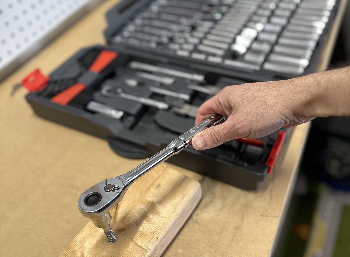A person using a wrench from the best mechanic tool set option
