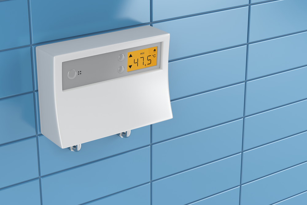 The control box for the best tankless gas water heater on a blue tiled wall.