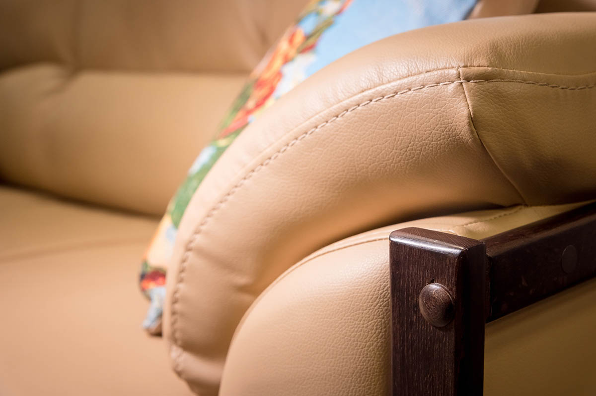 The arm of a leather couch that's been repaired with the best leather repair kit option