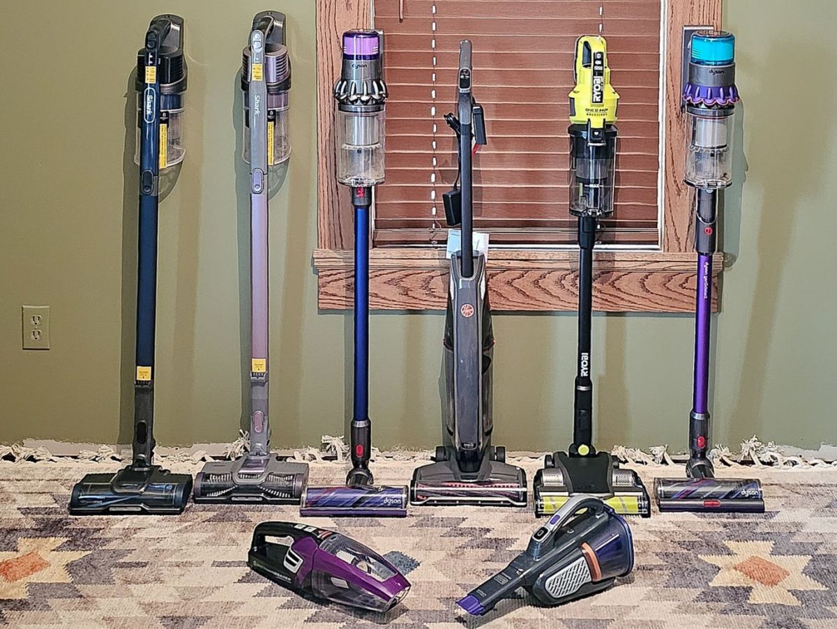 A Variety of the Best Cordless Vacuums for Pet Hair Lined Up Against a Wall, Showcasing stick and handheld models
