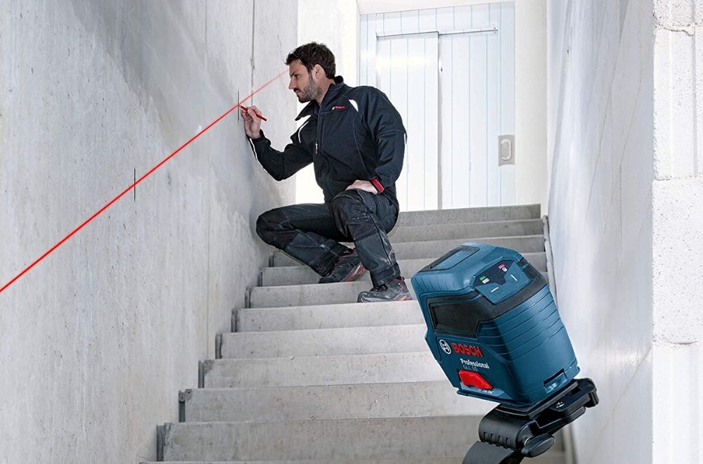 A person using the best level option to mark a straight line to install a stair railing