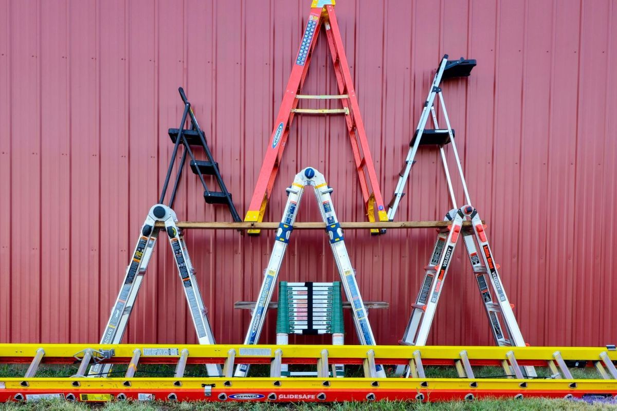 A group of the best ladders together next to the side of a barn or house
