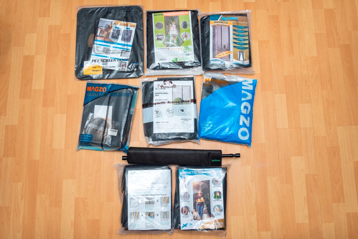 A group of the best magnetic screen door options in their packaging on a wood floor.