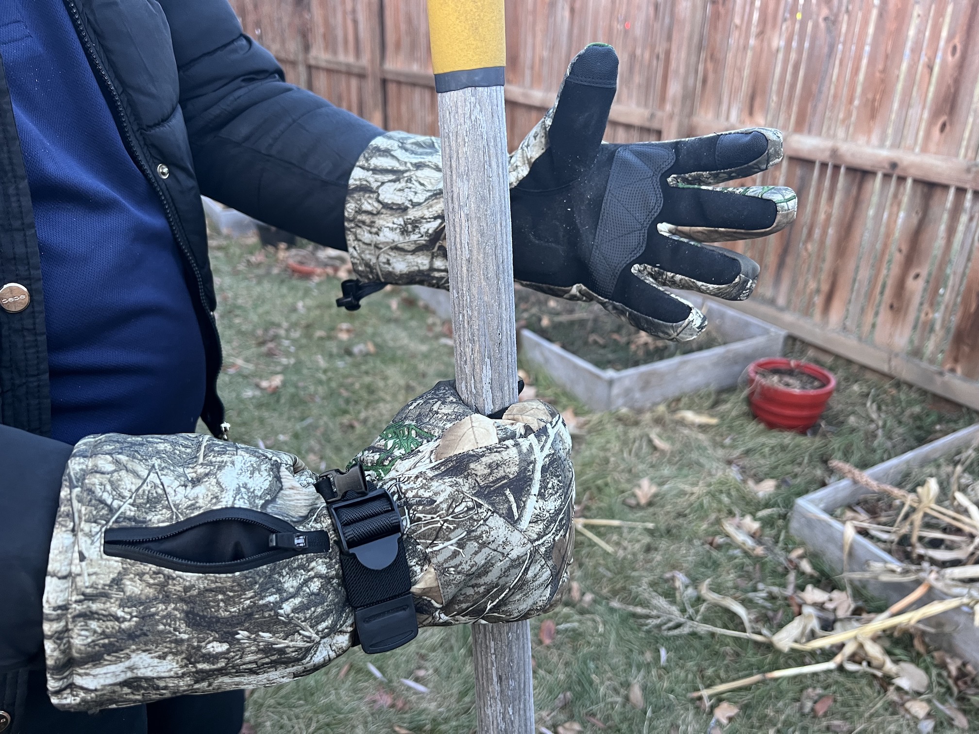 A person wearing heated gloves while grabbing a tool outside