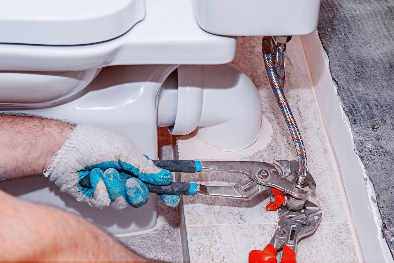 Removing an old toilet shut-off valve.