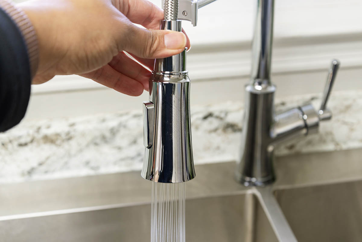 A person using the pull-down sprayer on the best kitchen faucet option