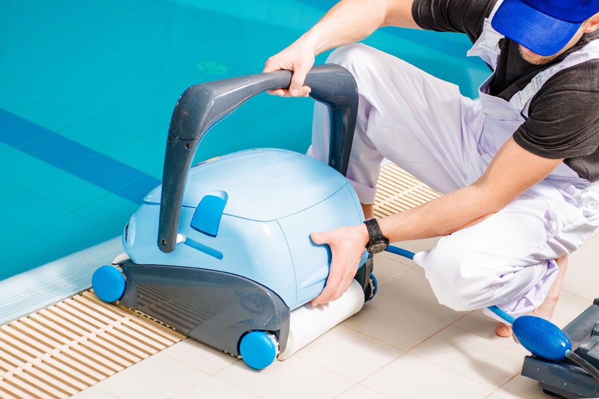 A man adjusting the Best Pool Vacuum Option in preparation for putting into a pool
