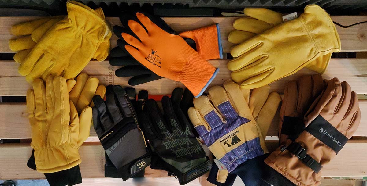 A group of the best winter work gloves on a picnic table before testing.