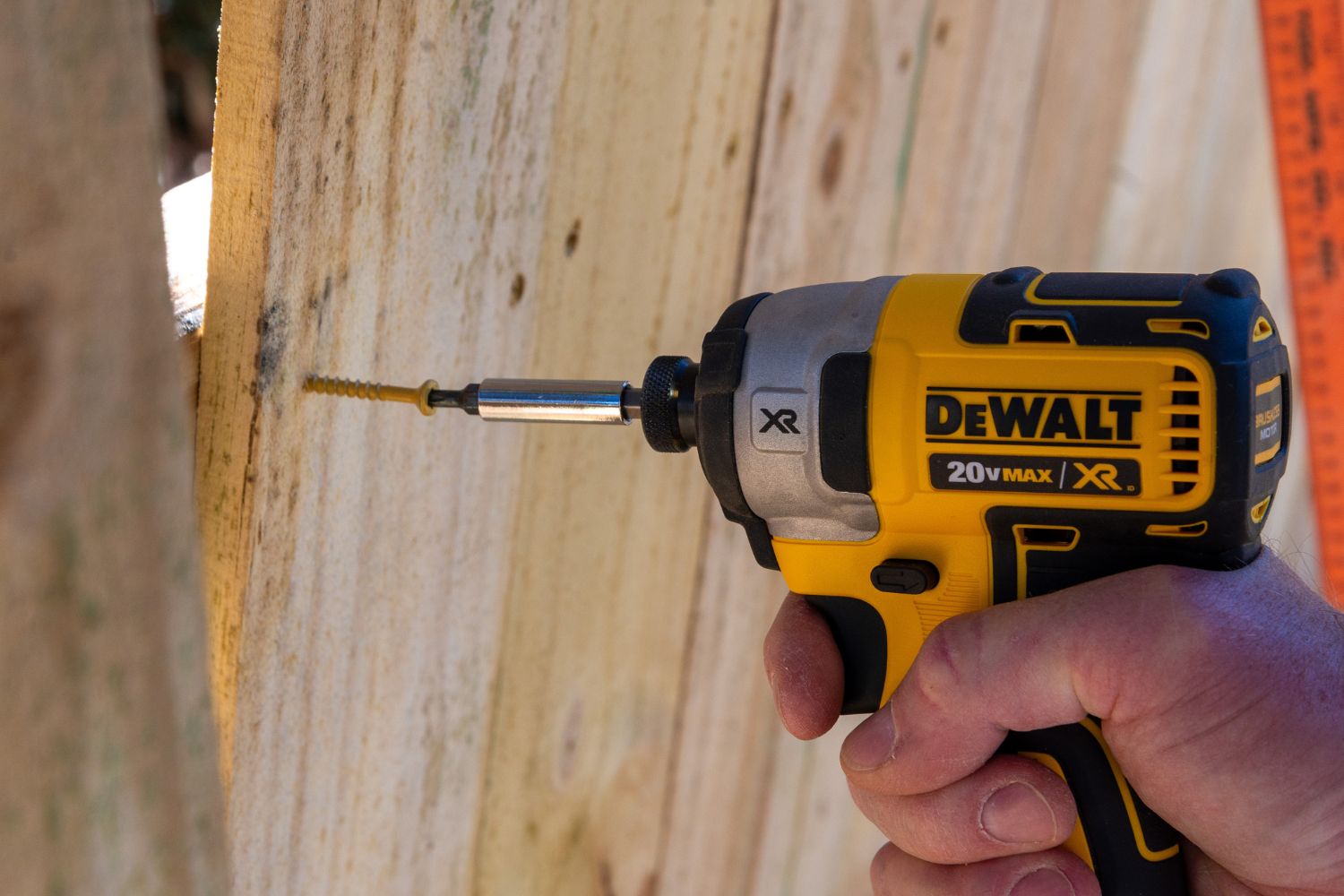 A person using a drill from the DeWalt 20V MAX XR Brushless 6-Tool Combo Kit to drive a screw into a board.