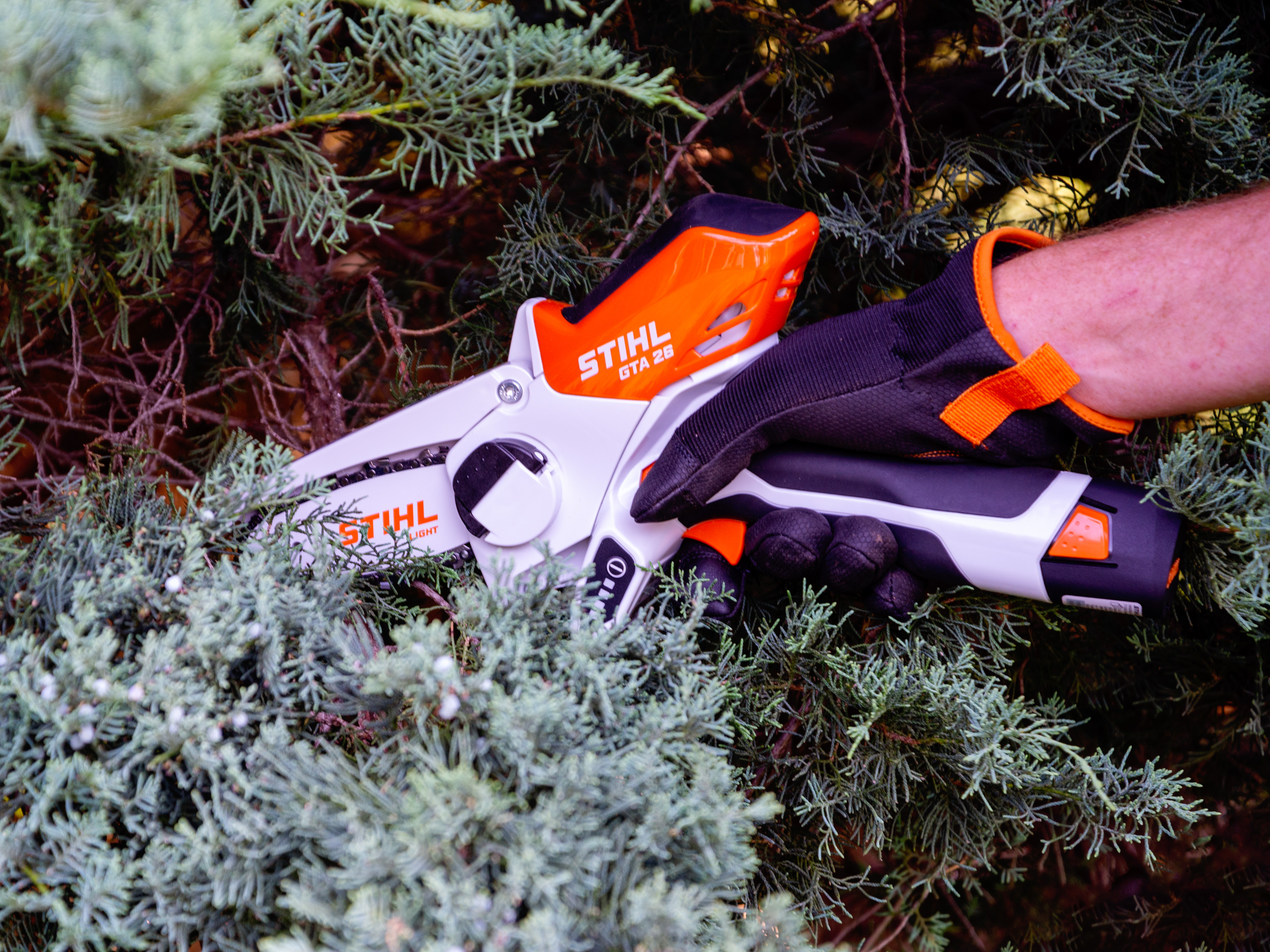 a hand holding one of the best battery chainsaws options