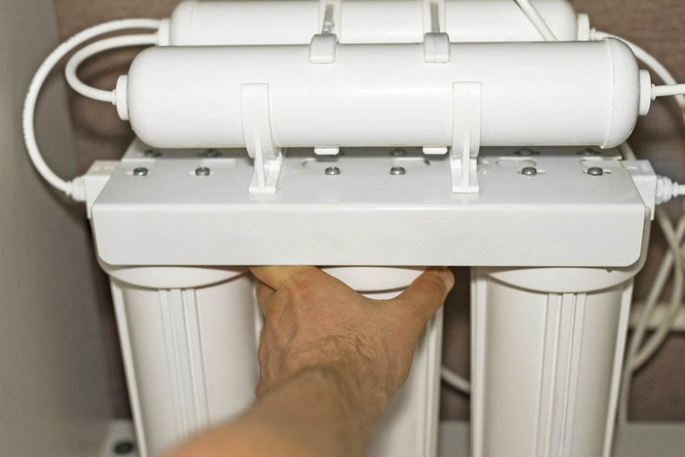 A person replacing a filter on the best reverse osmosis system option