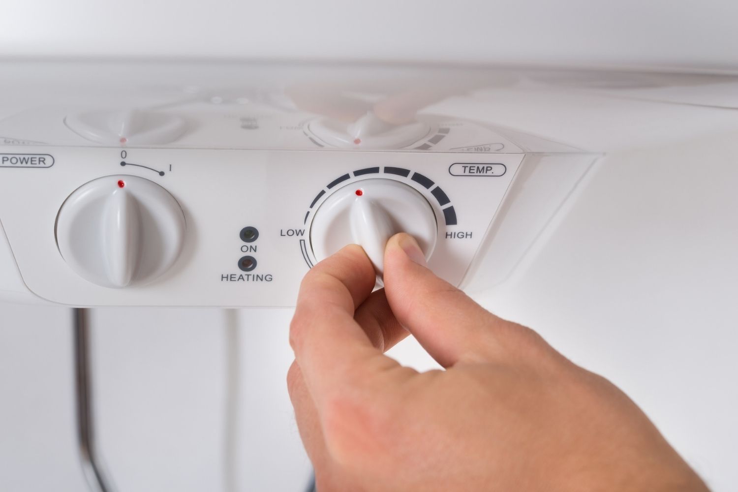 A person using the dial on the best water heater option to adjust the settings
