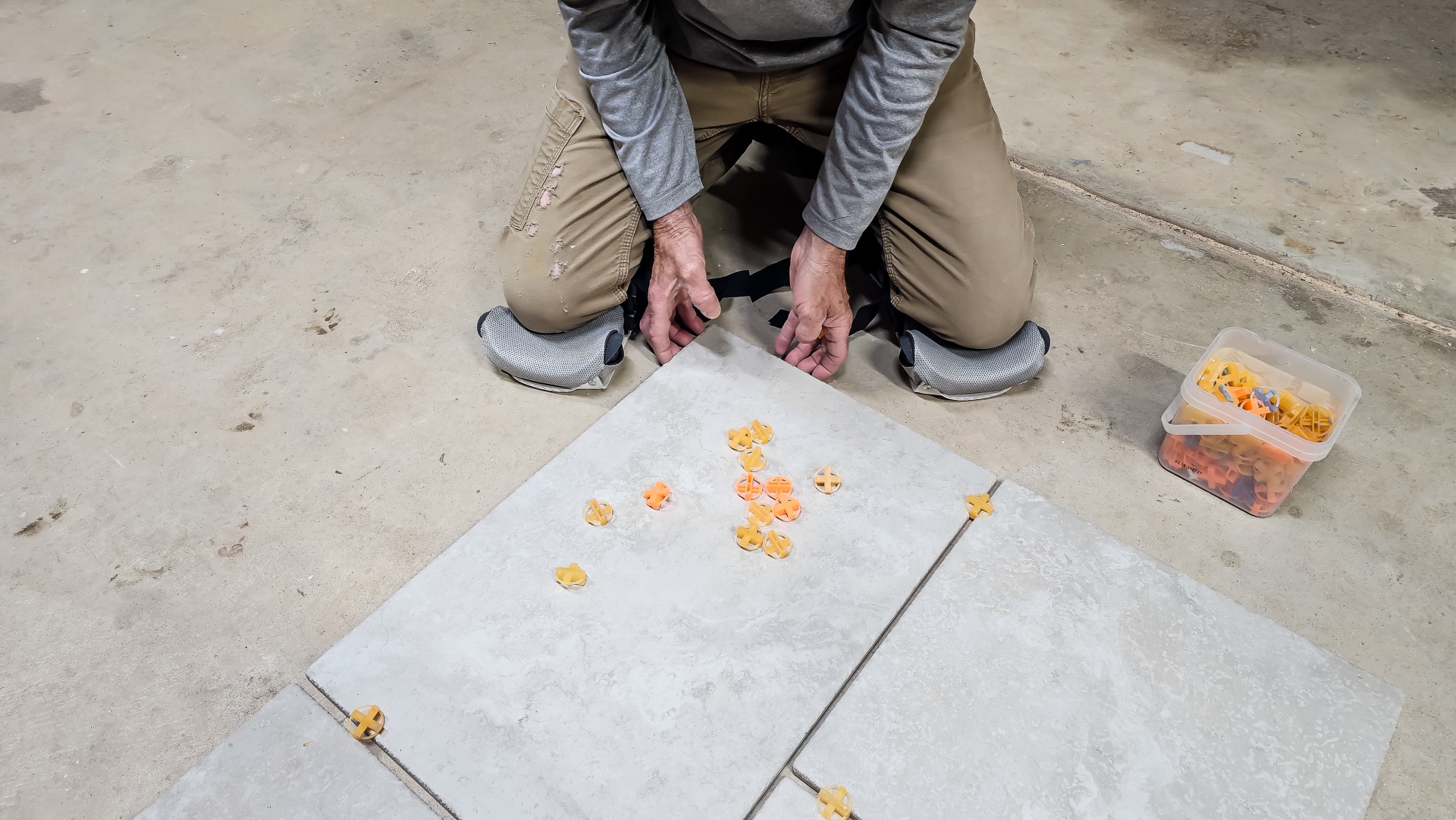 A person wearing the ProKnee AP16 while installing tile flooring during testing