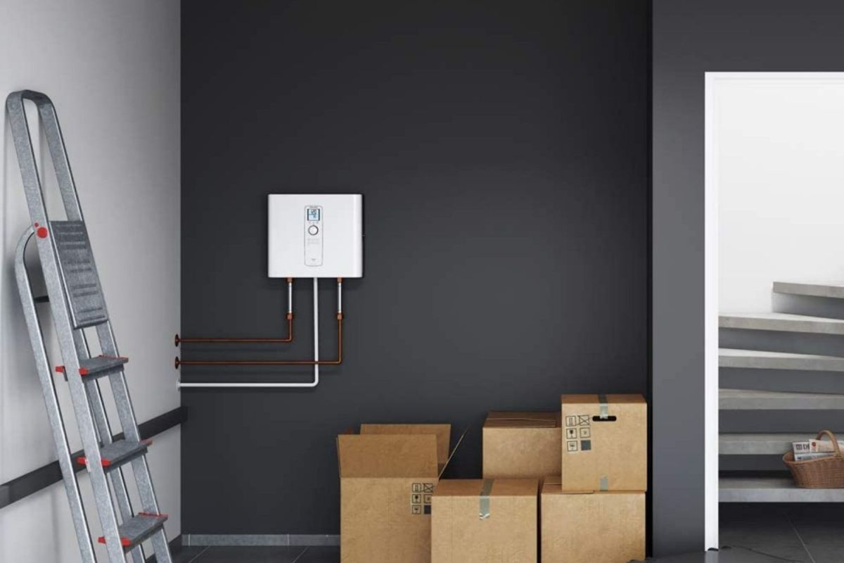 The best water heater option mounted on a basement wall near boxes of stored items and a ladder.