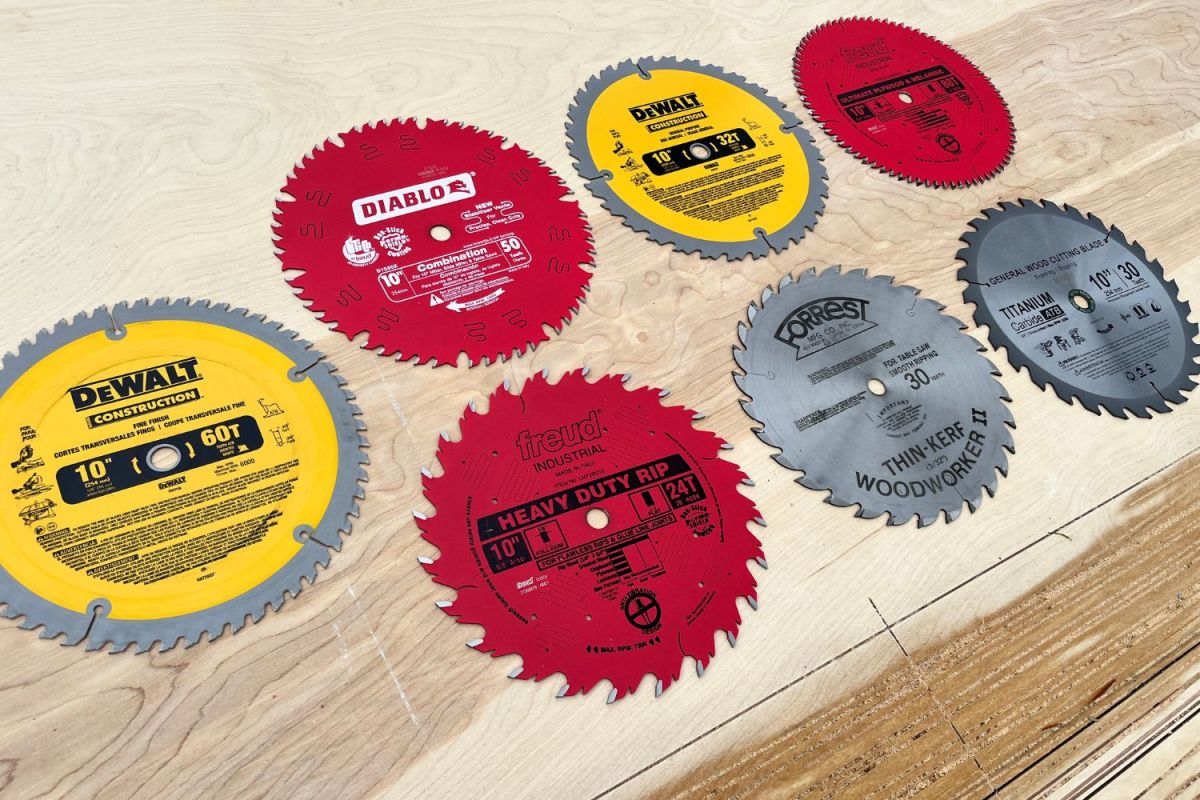 A group of the best table saw blades laid together on a large piece of wood