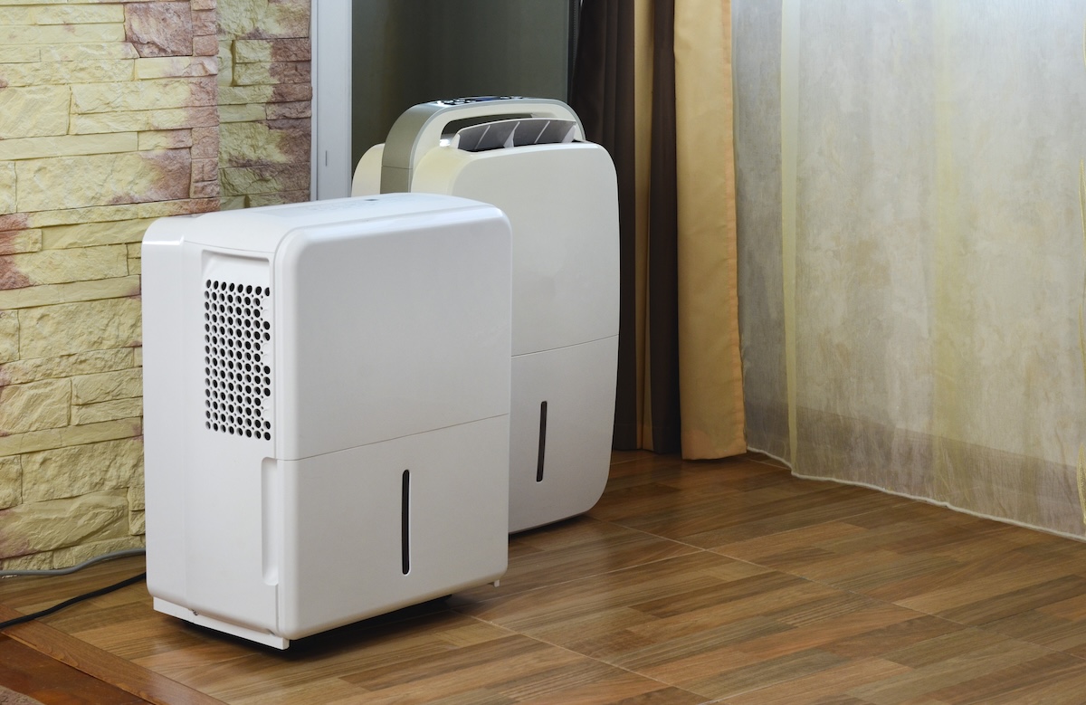 Two dehumidifiers in a basement.