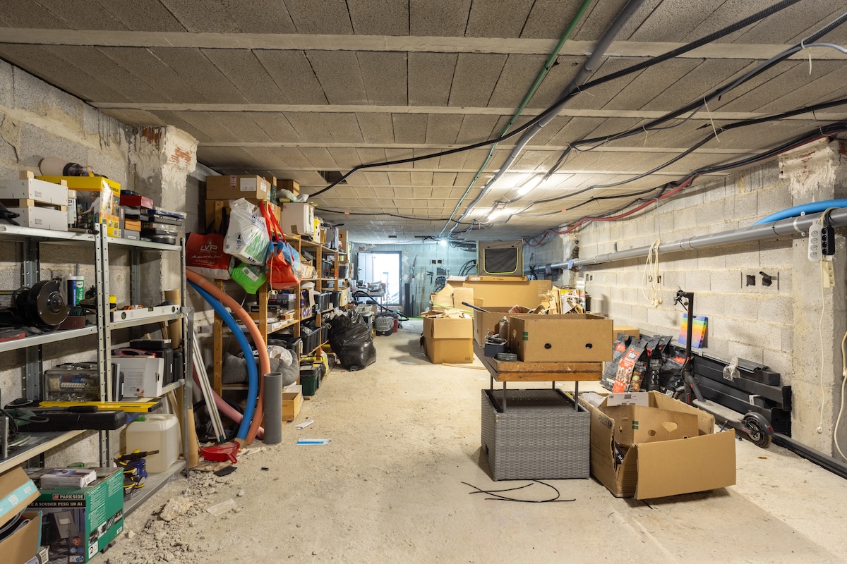 A home basement with boxes and other disorganized items.