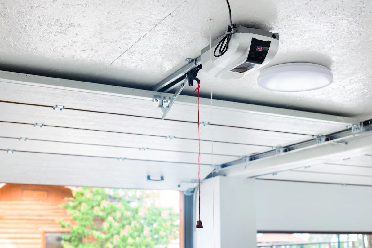 A garage door with a cord hanging from the operating box.