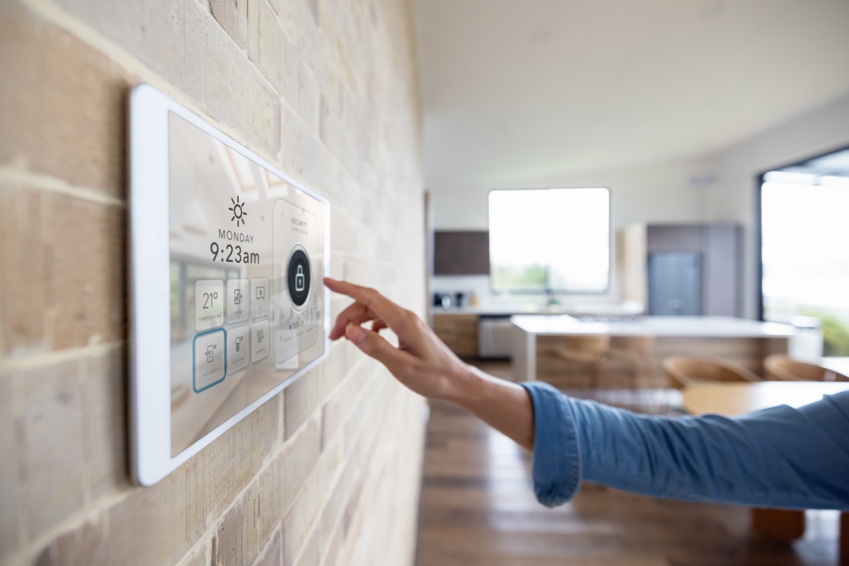 A woman uses a tablet to secure her smart home security system.