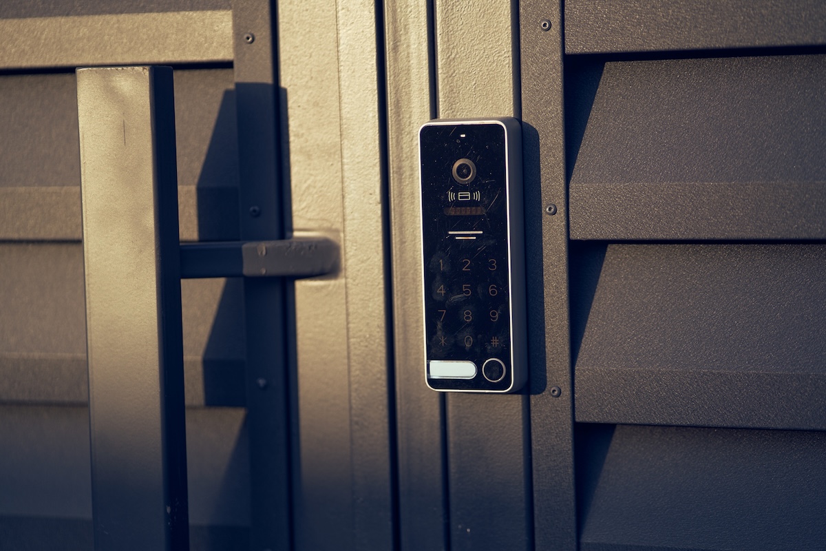 A smart lock with a keypad, camera, and fingerprint security system on a front door.