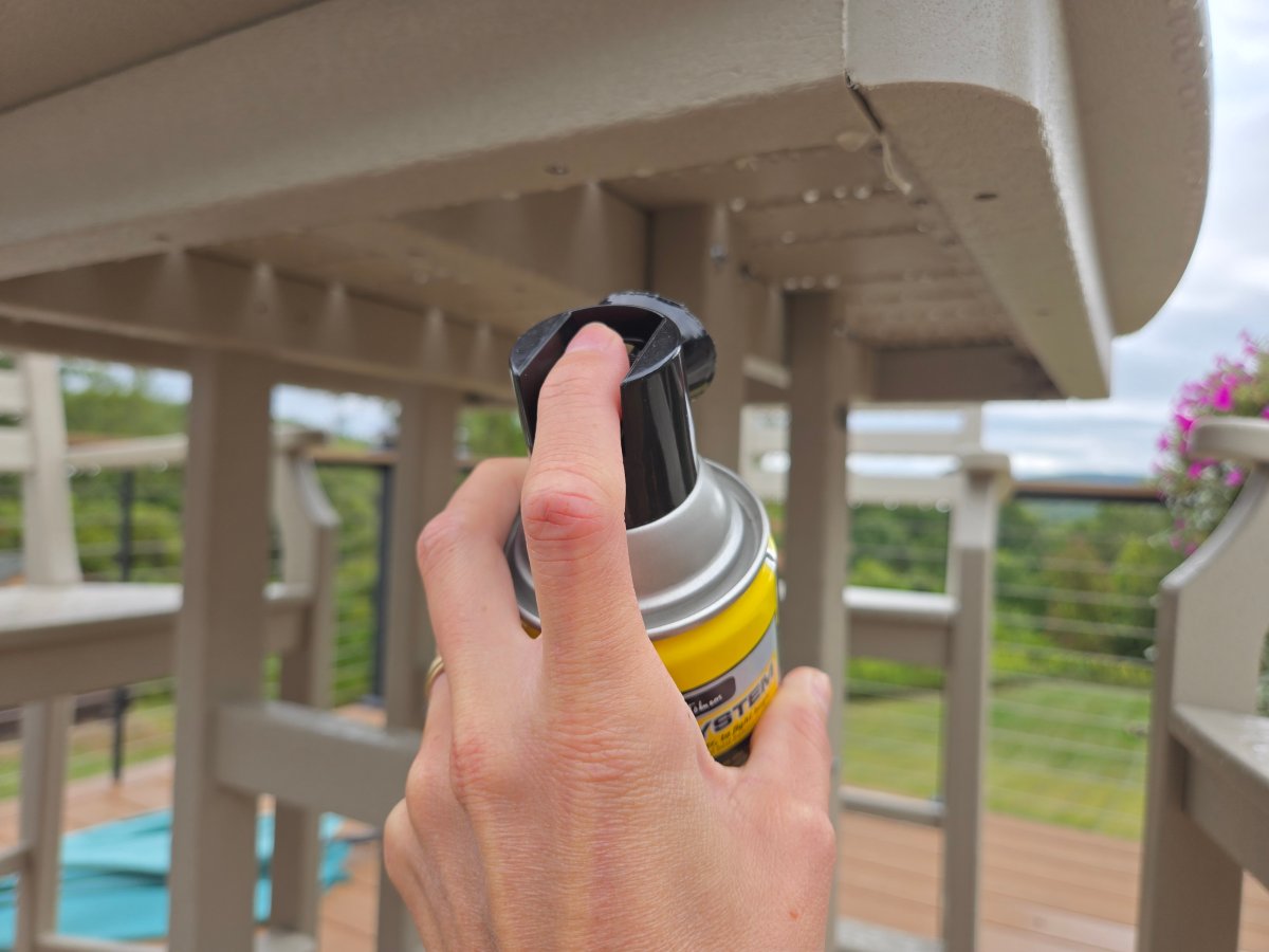 Raid Wasp and Hornet Spray being sprayed under table