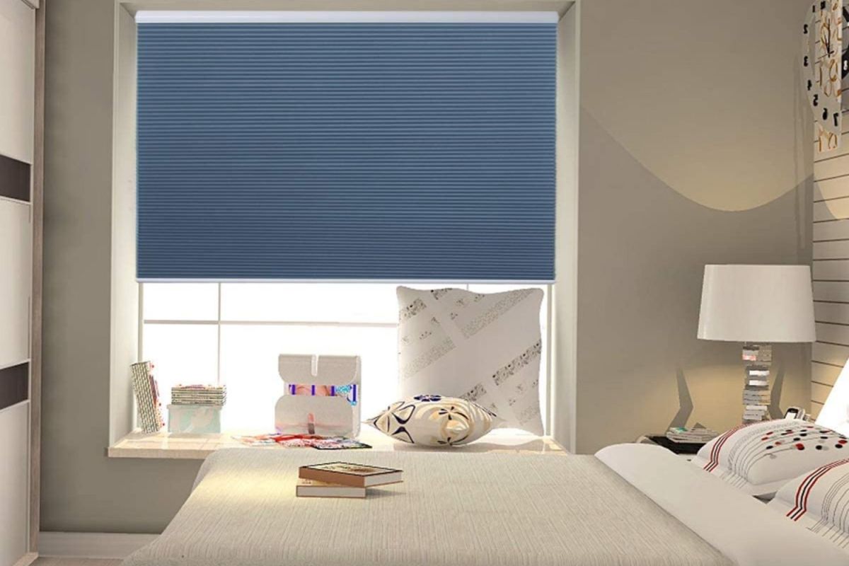A blue blackout shade installed over a bedroom window to block light and provide privacy.