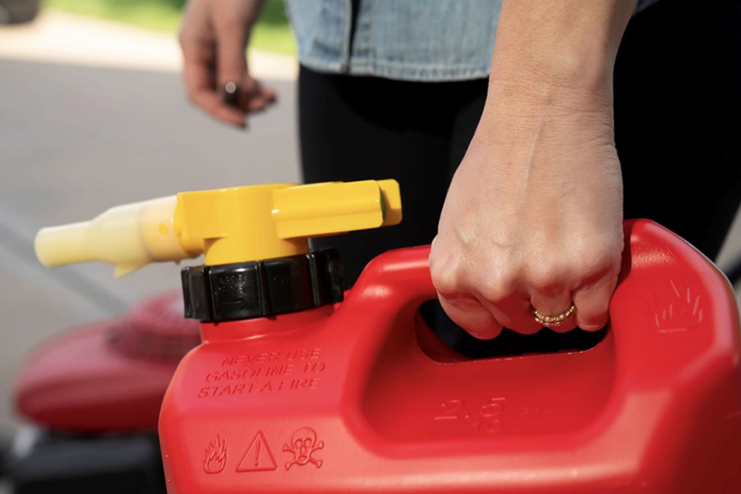 A person holding the best gas can with an attached pour spout