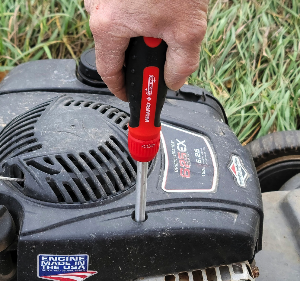 Ratcheting screwdriver in use to repair lawn mower