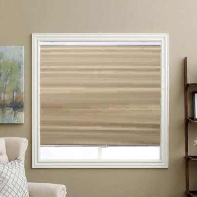 The Sbartar Cordless Blackout Honeycomb Blinds installed in living room window next to a chair.