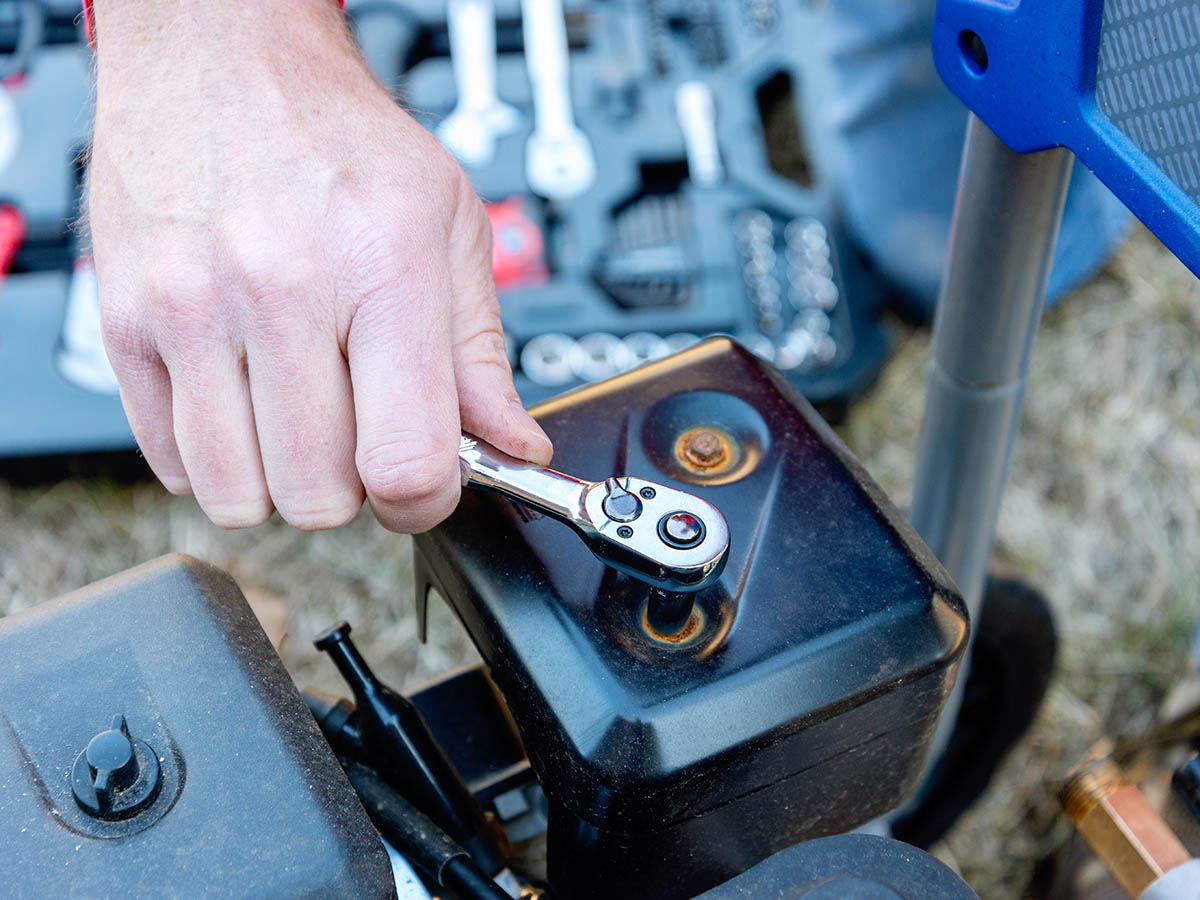 A product tester using a hand tool to tighten a nut during testing  