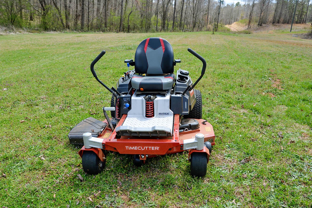 The best riding mower option sitting atop a very large yard next to a wooded area