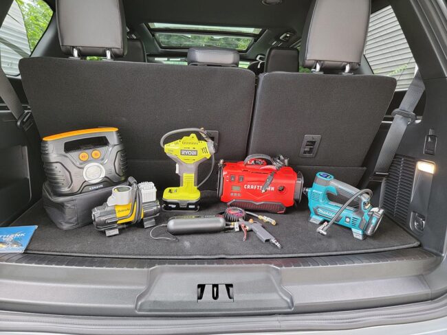 A group of the best tire inflator options placed together in the back of a car