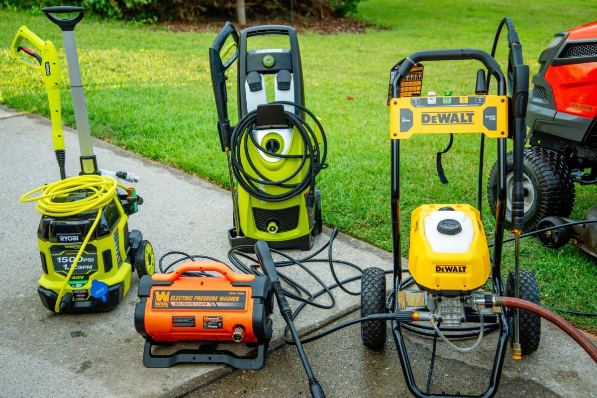 A group of the best electric pressure washers sitting on a recently cleaned driveway