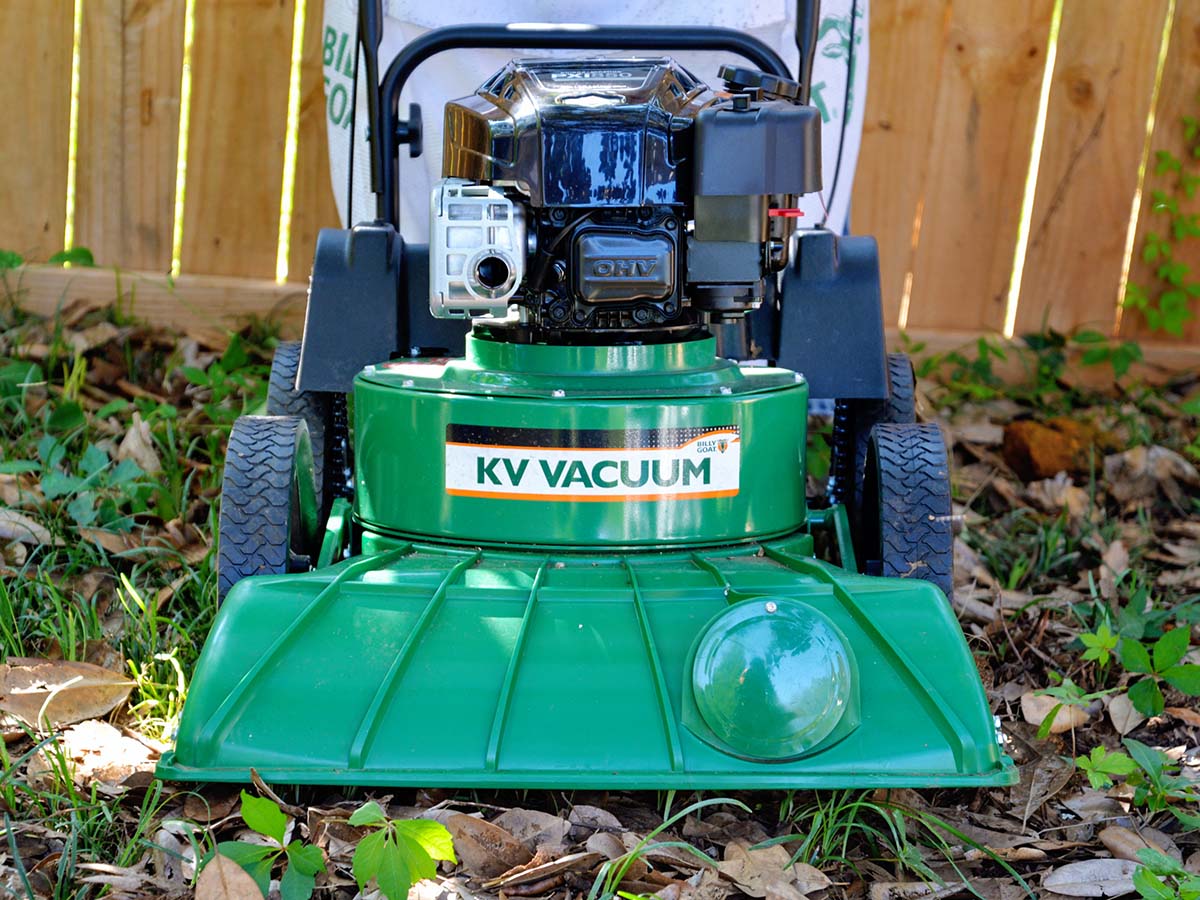 The best leaf mulcher option next to a fence in a yard and sitting on top of leaves