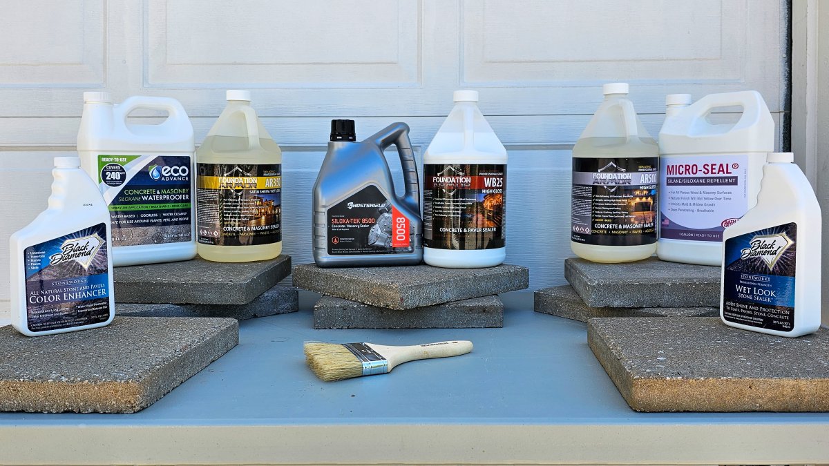 A group of the best paver sealers on top of pavers in a driveway before testing.