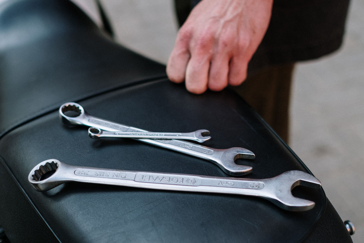 A variety of ratcheting wrenches on a motorcycle seat