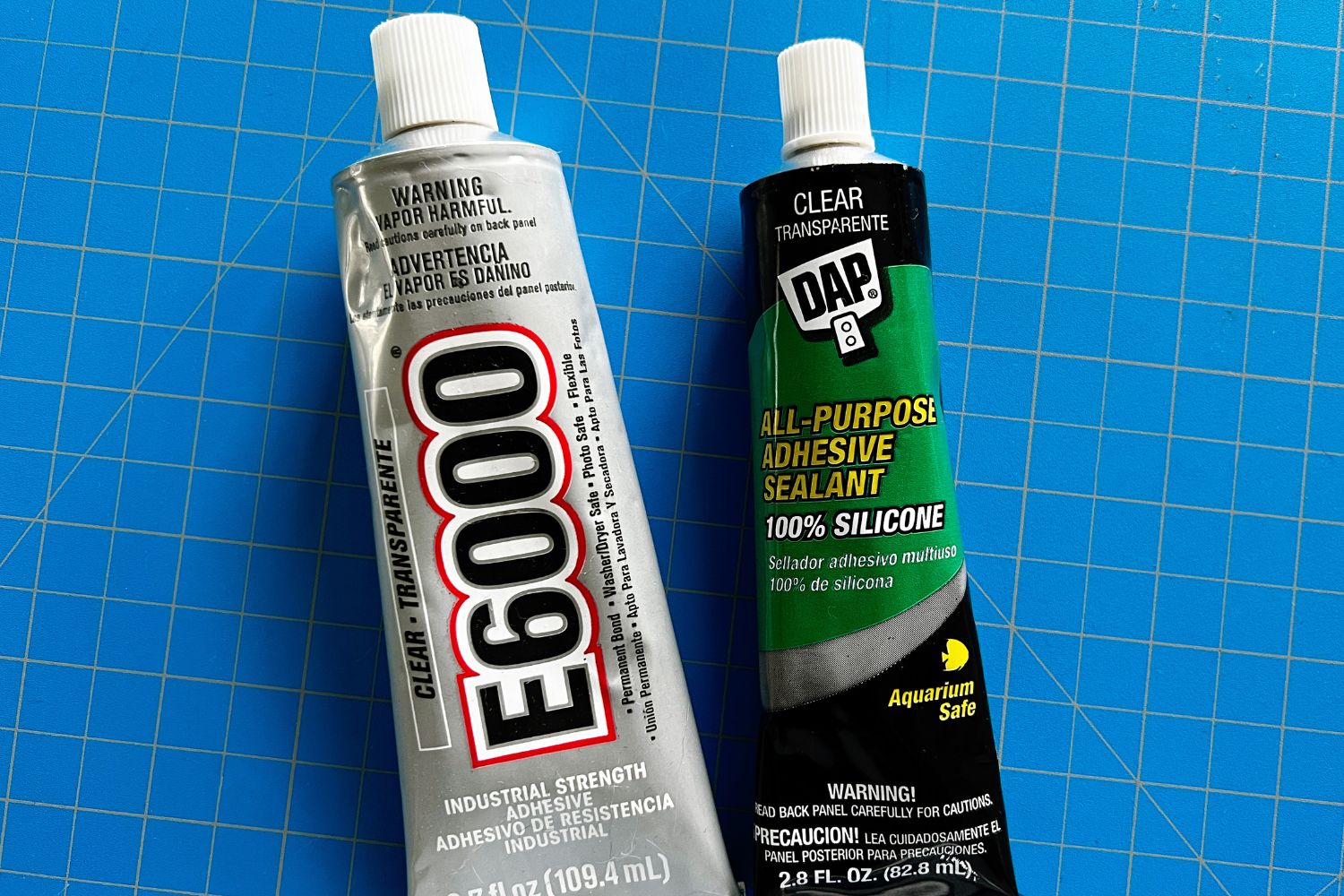 Two of the best glues for ceramics on a cutting mat before hands-on testing.