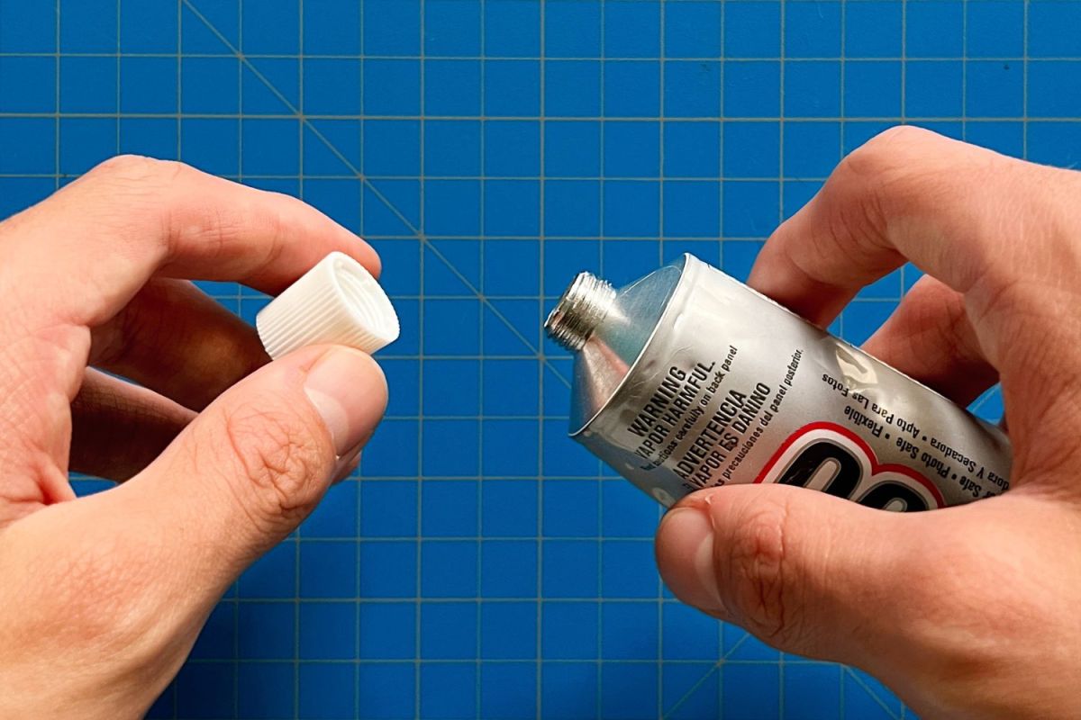 A person taking the cap off the Eclectic Products E6000 Craft Adhesive before testing the product.