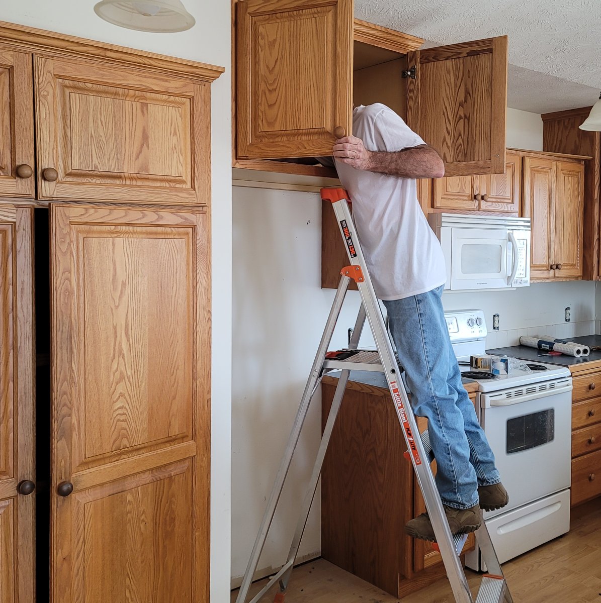 person standing on the second step from the Little Giant Flip step ladders  